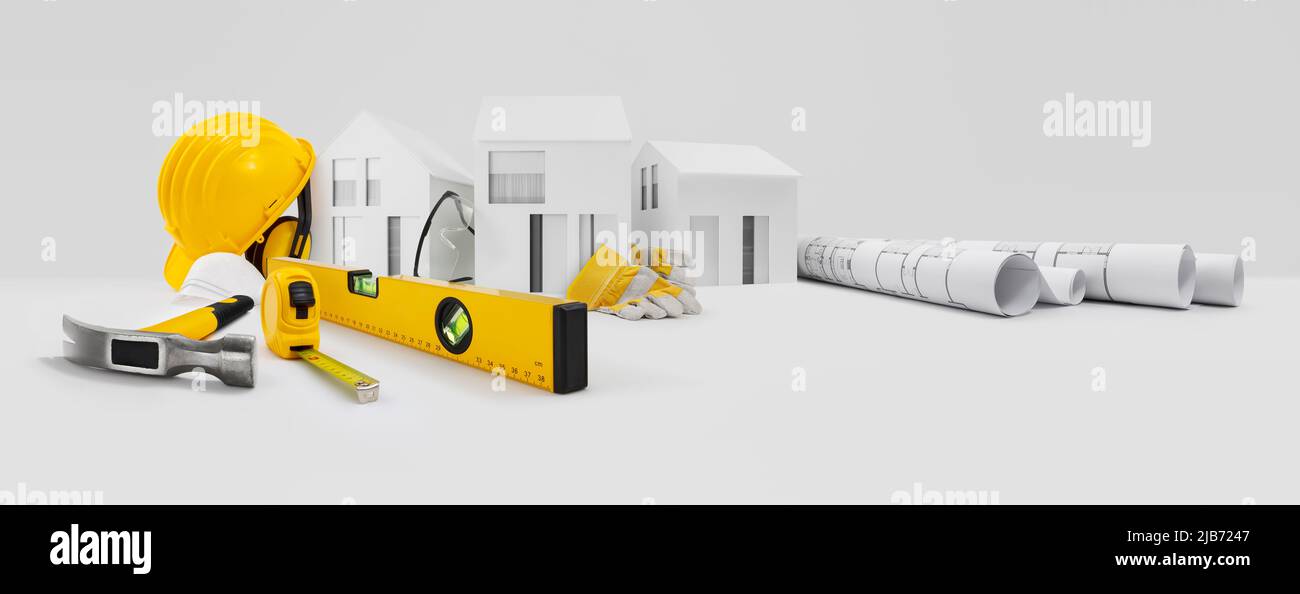 Plan de construction de maison. Outils de travail pour la construction. Maisons de modèles architecturaux, chapeau rigide jaune, mètre et niveau à bulle au-dessus de la table avec gants de sécurité, Banque D'Images