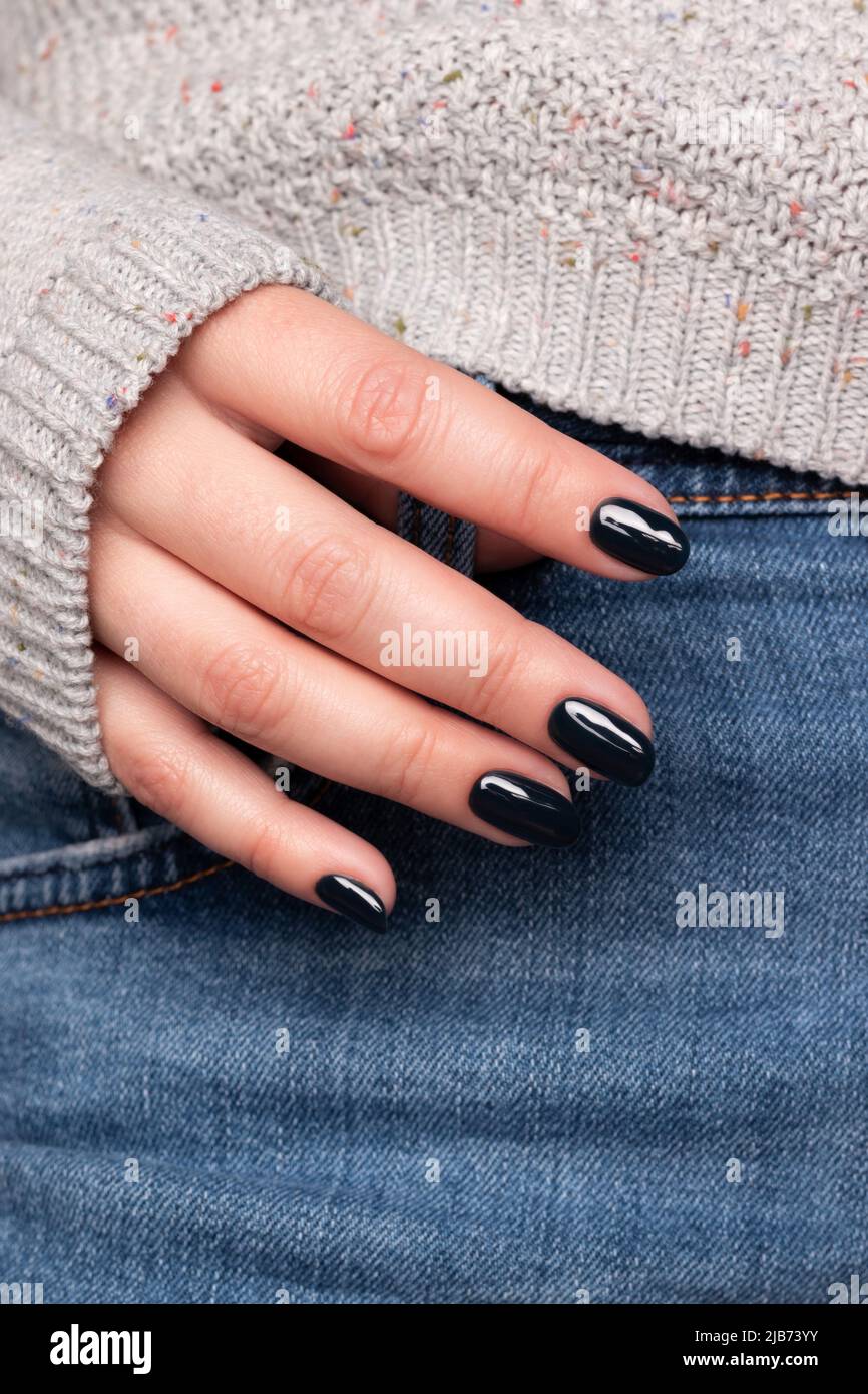 Main femelle avec une belle manucure - ongles noirs foncé, doigts de gros  plan Photo Stock - Alamy