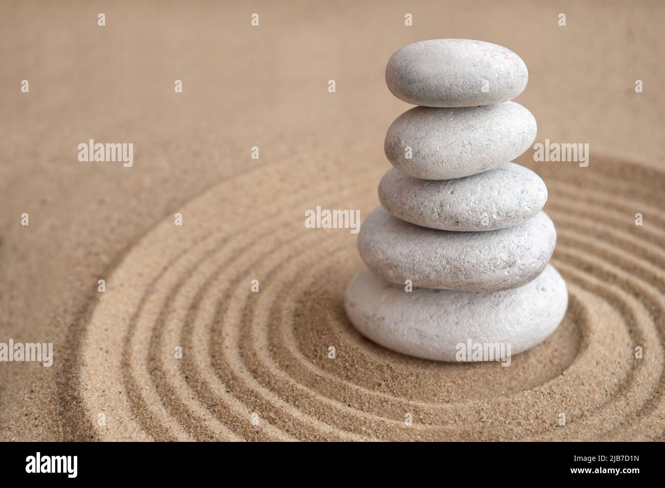 Yoga zen pierres équilibrées l'une sur l'autre à l'intérieur d'un cercle de sable Banque D'Images
