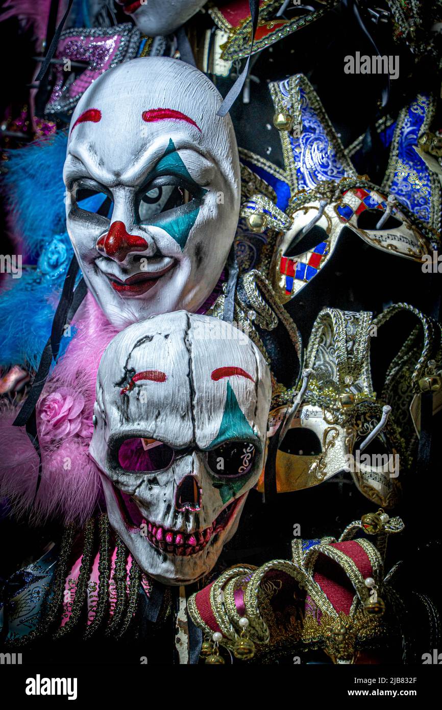 Venise, Italie - 18.02.2022: Gros plan sur le terrifiant masque clown et le masque crâne accrochés entre les masques vénitiens traditionnels. Joyeux Halloween. Banque D'Images