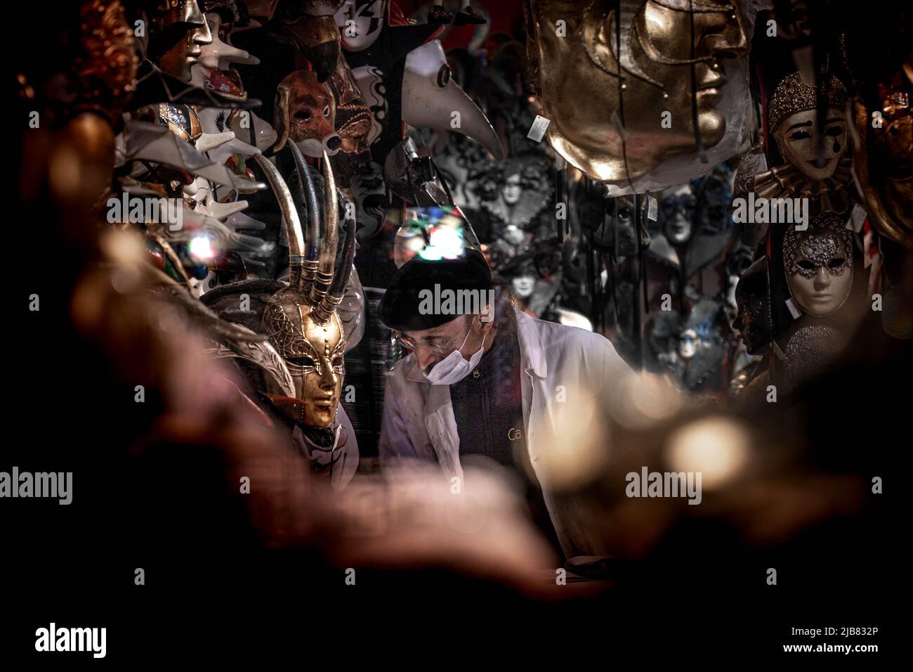 Venise, Italie - 18.02.2022: Une maltraitance d'un homme mûr écoutant humblement le grand masque avec des cornes a pivoté dans un magasin fermé de masque à Venise, Italie Banque D'Images