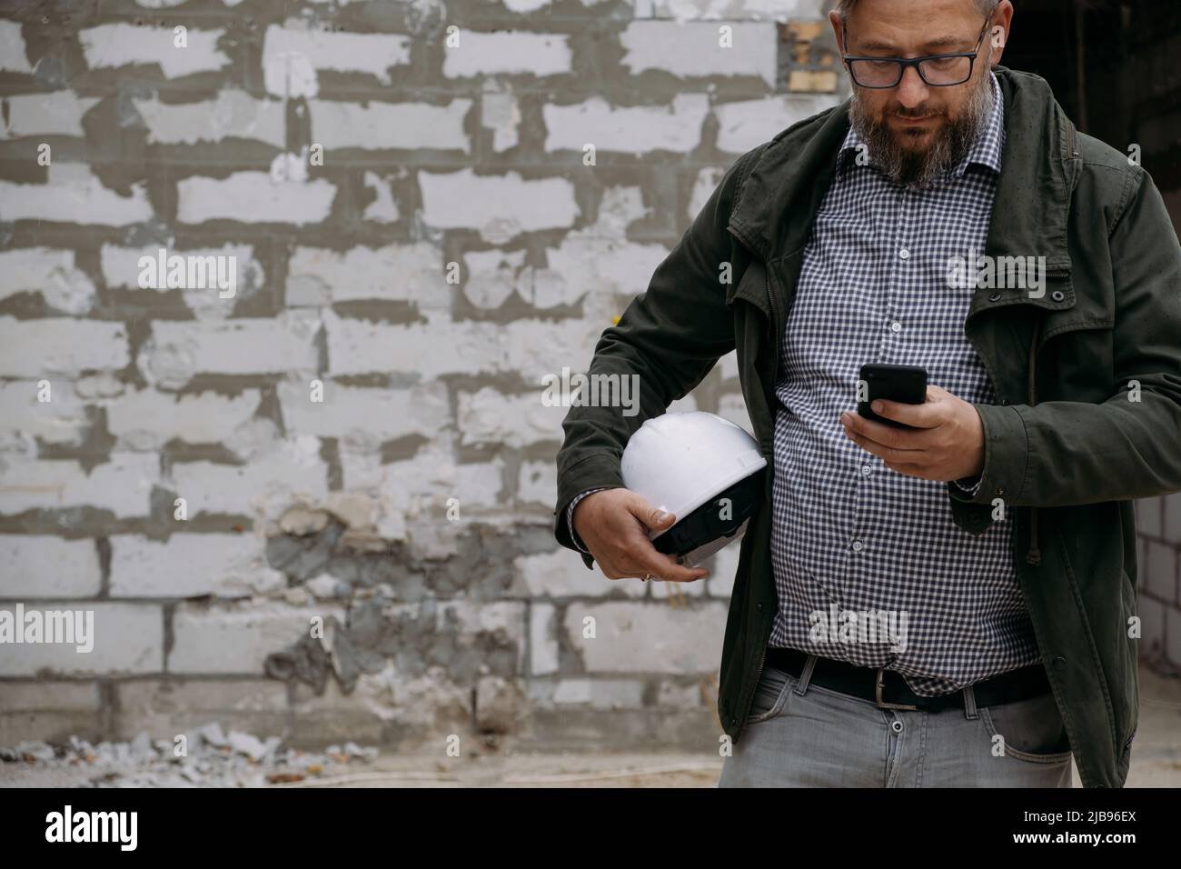 Contremaître sur le chantier de construction. Architecte discutant du projet avec des ingénieurs de construction de téléphone intelligent qui planifient le chantier. Communication Banque D'Images