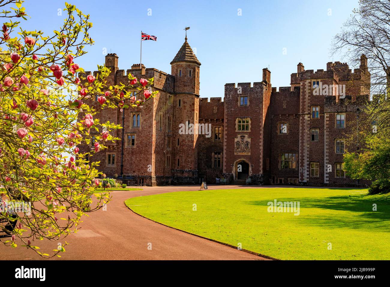 L'avant ouest du château de Dunster avec un drapeau Union Jack en vol, Somerset, Angleterre, Royaume-Uni Banque D'Images