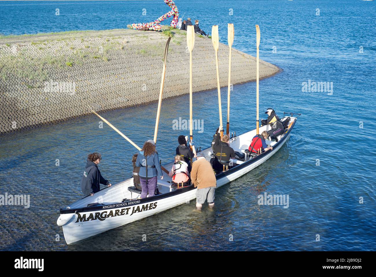 Une équipe d'aviron de gig se présente au port d'Appledore, au Devon, au Royaume-Uni Banque D'Images