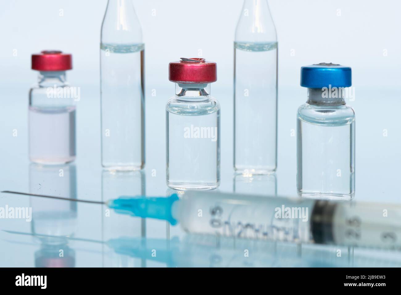 flacon en verre de liquide, un vaccin et une seringue médicale gros plan sur fond bleu. Le concept de vaccination contre le coronavirus . Bannière, copie sp Banque D'Images