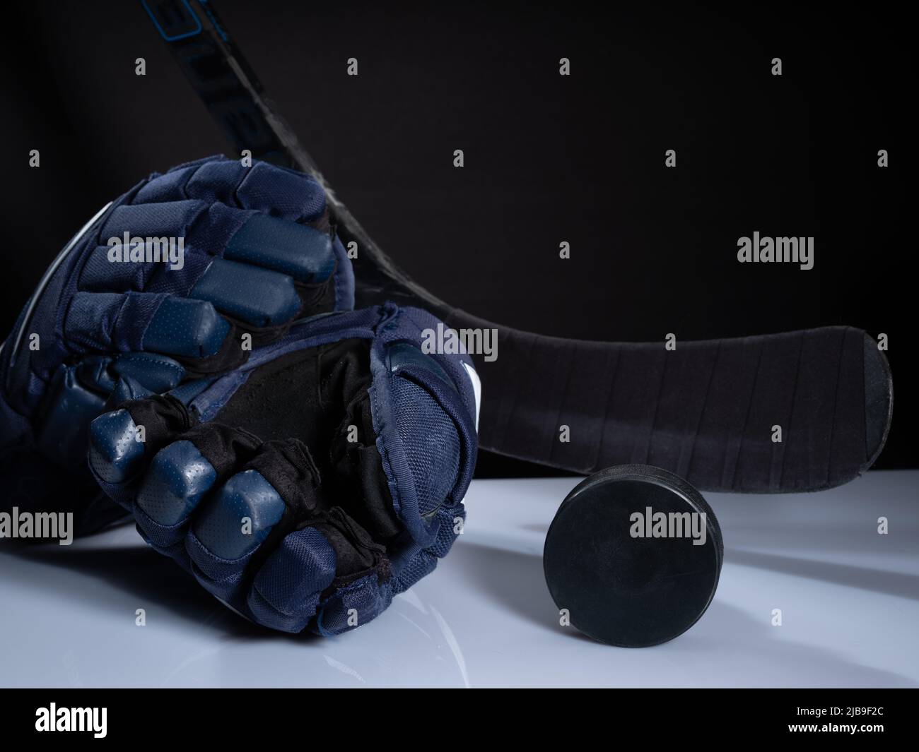 Helsinki / Finlande - 4 JUIN 2022 : gros plan de l'équipement de hockey sur glace sur fond sombre. Casque, bâton, palet et gants de hockey sur glace Banque D'Images