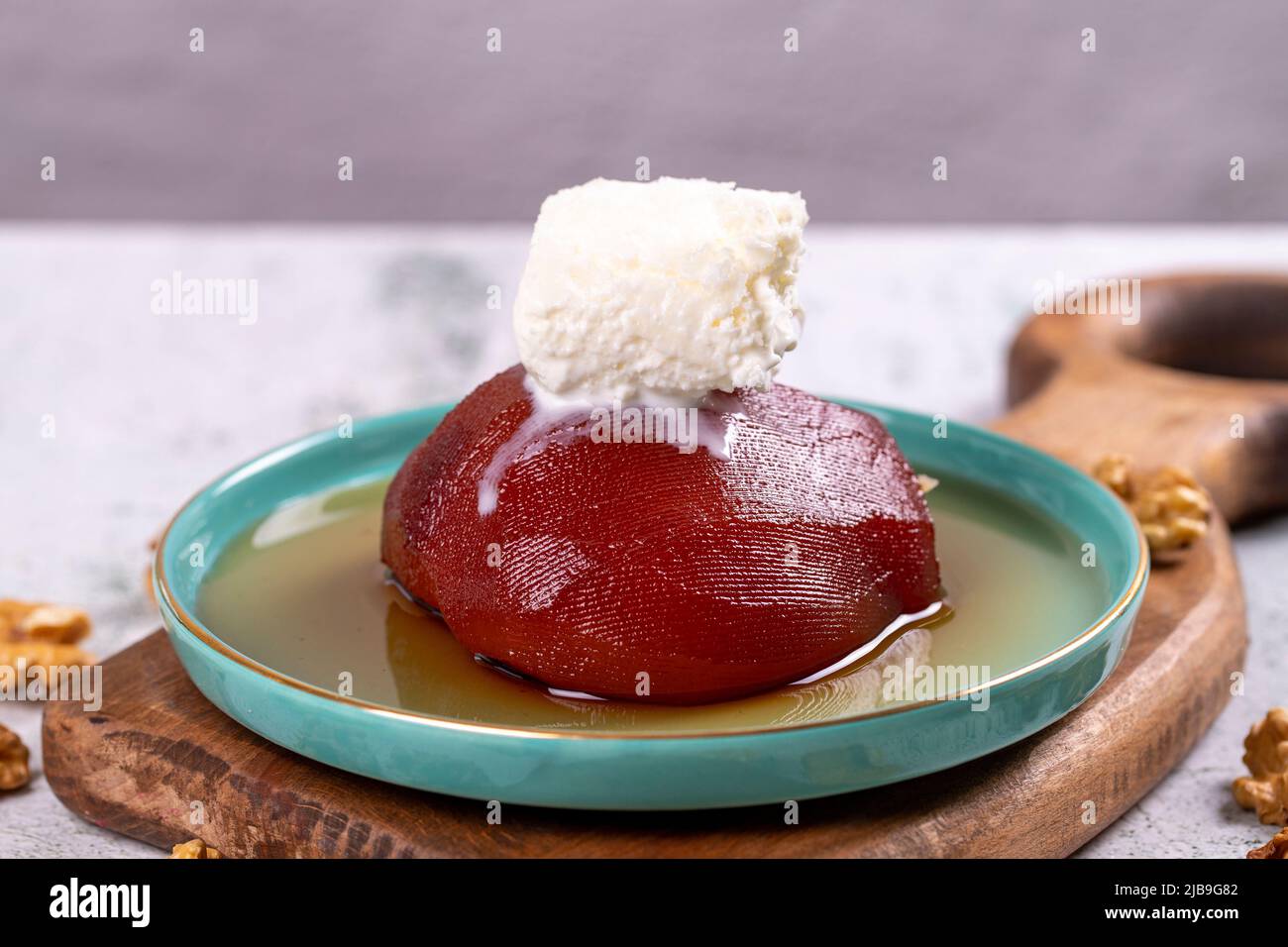 Dessert de coing. Spécialités turques traditionnelles. Dessert de coing avec crème sur fond de pierre. Gros plan. Nom local ayva tatlisi Banque D'Images