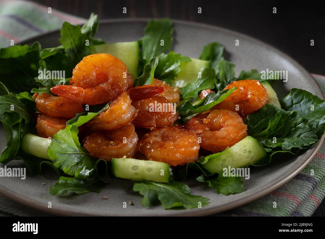 Salade fraîche aux crevettes grillées, concombres et arugula magnifiquement servis sur une assiette. Banque D'Images