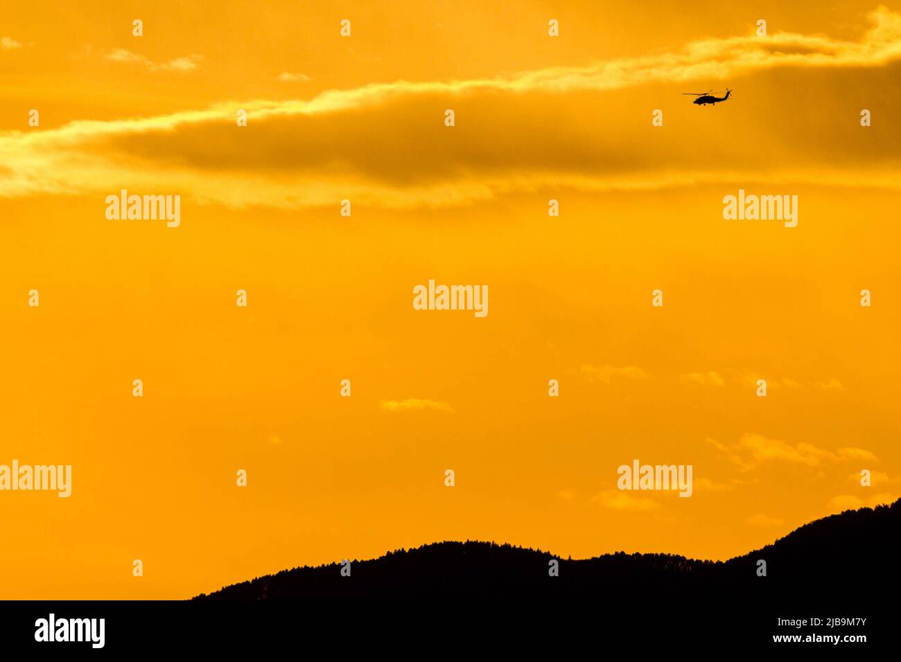 Les hélicoptères Sikorsky SH-60 Seahawk survolant Chou Rinkan, Kanagawa au coucher du soleil. Banque D'Images