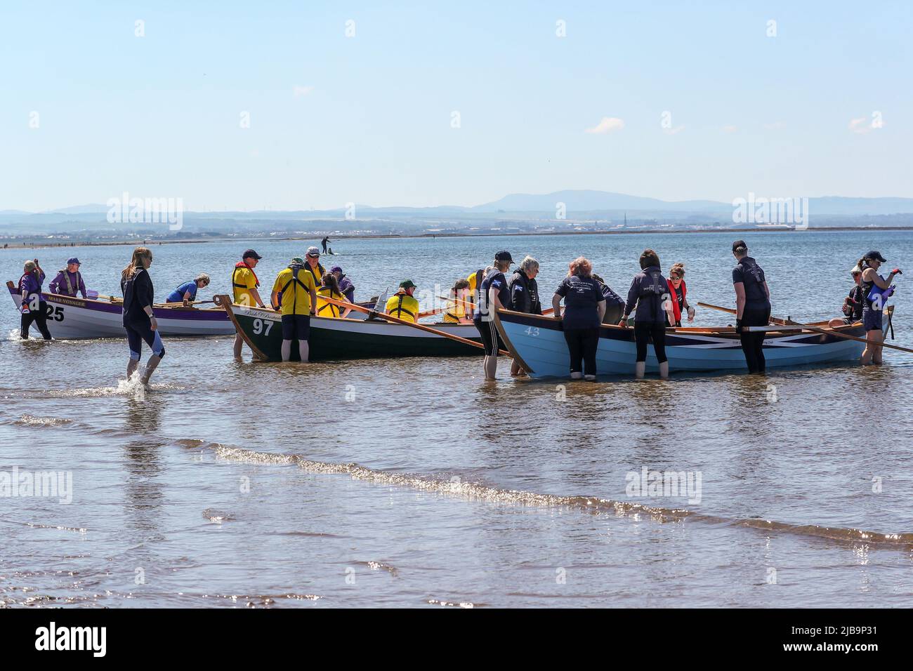 Troon, Royaume-Uni. 04th juin 2022. 04 juin 2022. Troon, Royaume-Uni. Le Troon Coastal Rowing Club (TCRC) a tenu sa régate annuelle sur le Firth de Clyde en naviguant depuis la plage sud de Troon, Ayrshire, Royaume-Uni. Les petits bateaux sont traditionnels, faits à la main, bois, 4 équipage, skiffs de pêche, sur la base d'une conception vieille de 300 ans. La course exige que les concurrents s'en prennent à un parcours fixe d'au moins 2 kilomètres, partant du rivage et à leur retour, un membre de l'équipe doit prendre un bâton de Troon rock (confiserie) et courir jusqu'à la ligne d'arrivée avec lui. L'événement a attiré des concurrents de divers clubs d'aviron côtiers d'Écosse Banque D'Images