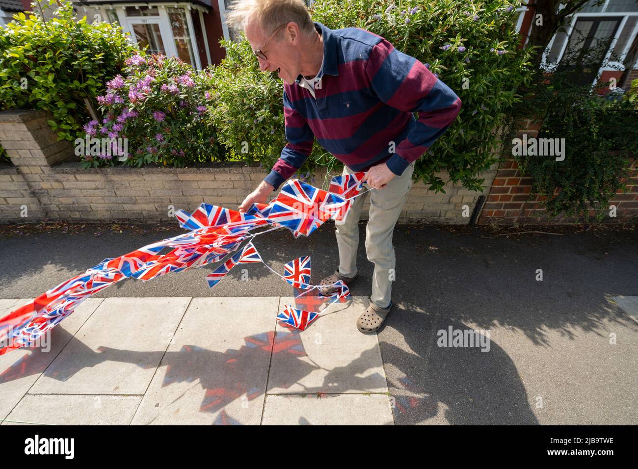 Merton Park, Londres, Royaume-Uni. 4 juin 2022. Un résident local se bat avec de longues files d'attente dans le vent de rafales tout en préparant la fête de rue Poplar Road South qui aura lieu sur une route fermée le dimanche 5th juin. Crédit : Malcolm Park/Alay Live News. Banque D'Images