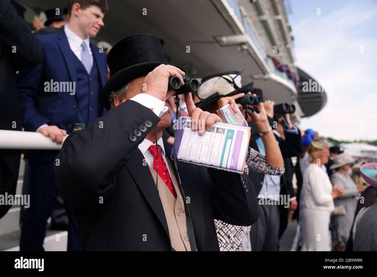 Les Racegoers regardent l'action à travers des jumelles le Derby Day pendant le Cazoo Derby Festival 2022 à Epsom Racecourse, Surrey. Date de la photo: Samedi 4 juin 2022. Banque D'Images