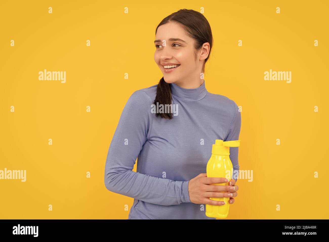 bonne jeune femme tenant une bouteille de sport avec de l'eau, soif Banque D'Images
