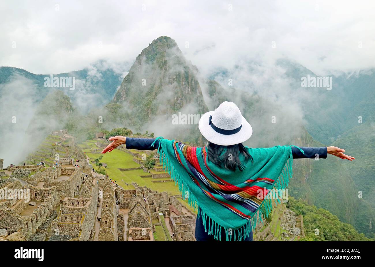 Femme du Blue Poncho impressionnée par l'étonnante ancienne Citadelle inca  de Machu Picchu, site classé au patrimoine mondial de l'UNESCO dans la  région de Cusco au Pérou Photo Stock - Alamy