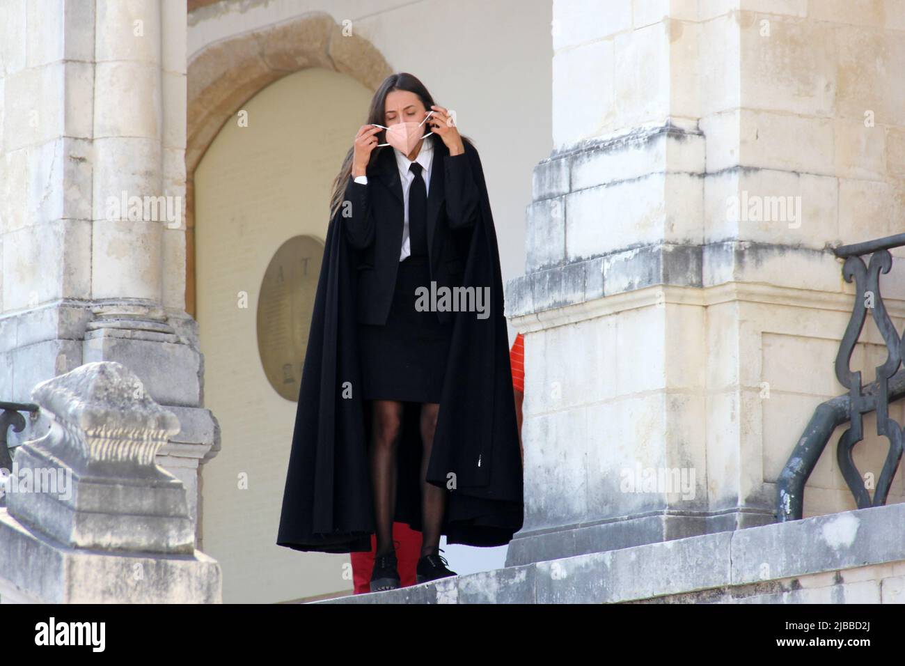Étudiant en manteau noir traditionnel, portant un masque, sur les marches  du bâtiment historique de l'université, Coimbra, Portugal Photo Stock -  Alamy
