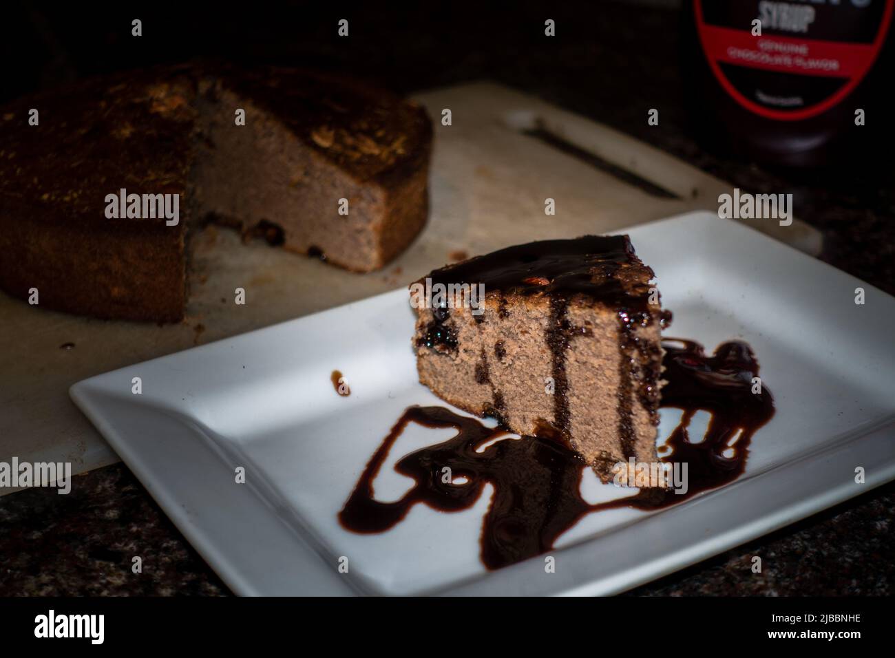 Une tranche de gâteau à la cannelle fait maison avec du chocolat fondu sur le dessus. Inde Banque D'Images