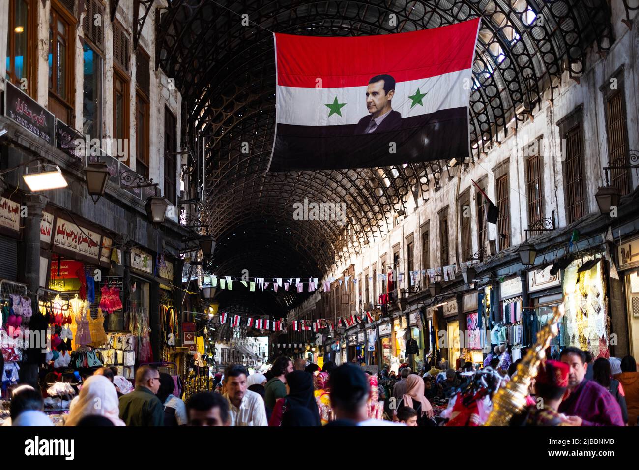 Damas, Syrie - Mai 2022 : portrait de Bachar el-Assad, président de la Syrie sur le drapeau syrien à Suq à Damas Banque D'Images