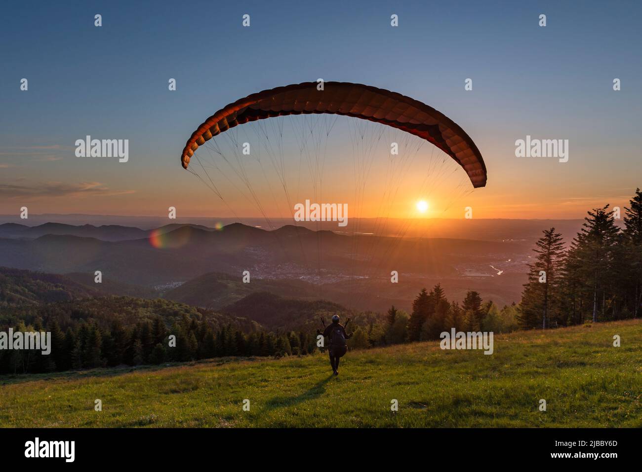 Parapente au décollage jusqu'au coucher du soleil sur le site de lancement du moulin du Diable dans la vallée de Murg, dans les montagnes de la Forêt-Noire, en Allemagne Banque D'Images