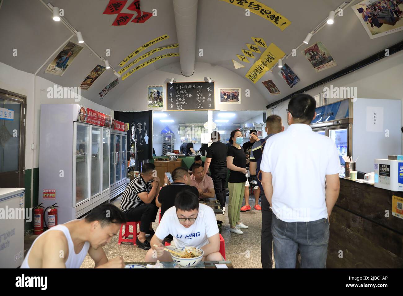 XI'AN, CHINE - 5 JUIN 2022 - les gens mangent de la nourriture et se rafraîchissent dans un magasin de nouilles dans un abri de RAID aérien à Xi 'an, province de Shaanxi, Chine, 5 juin 2022. Banque D'Images