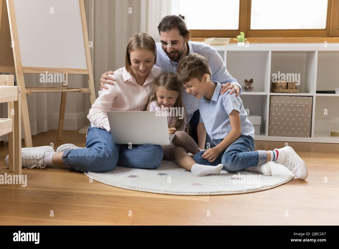 Couple et enfants passent leurs vacances à l'aide d'un ordinateur portable Banque D'Images