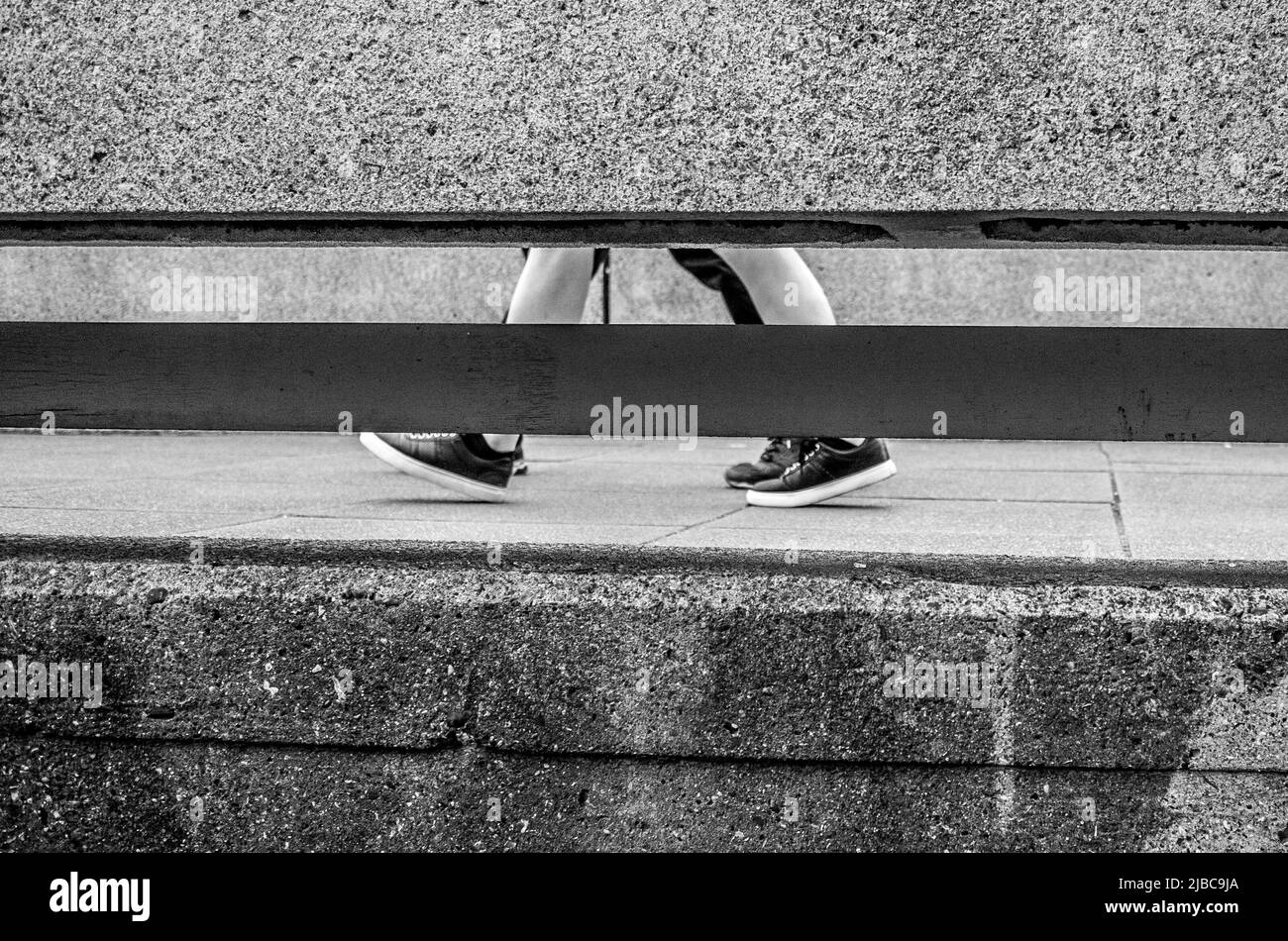 Pieds et jambes marcher le long d'une passerelle de style brutaliste à Londres Southbank - Queen Elizabeth Hall. Banque D'Images