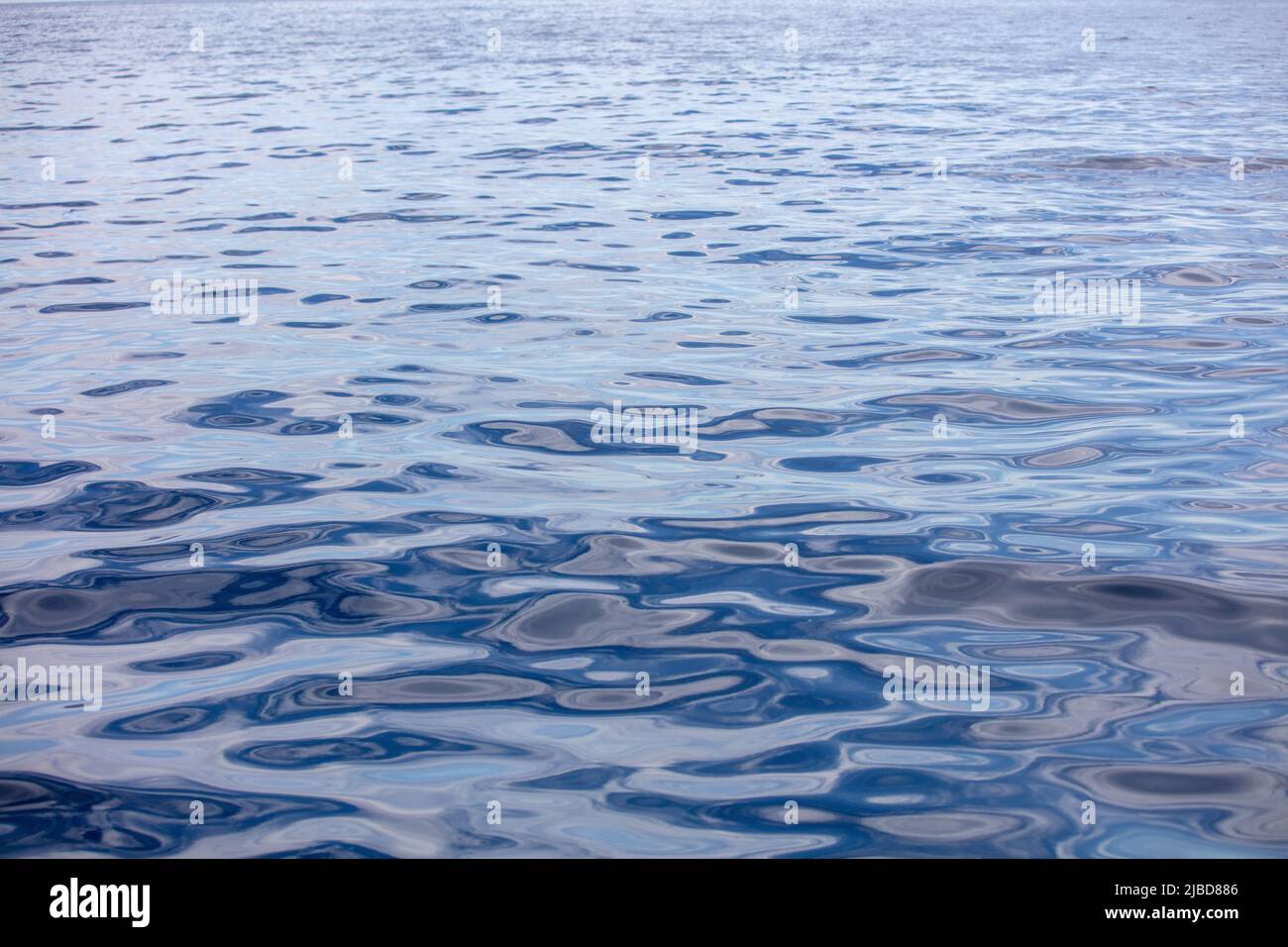 La surface de l'eau de mer est calme avec de petites ondulations. Océan fixe, fond bleu foncé. Mer Egée, Méditerranée Banque D'Images