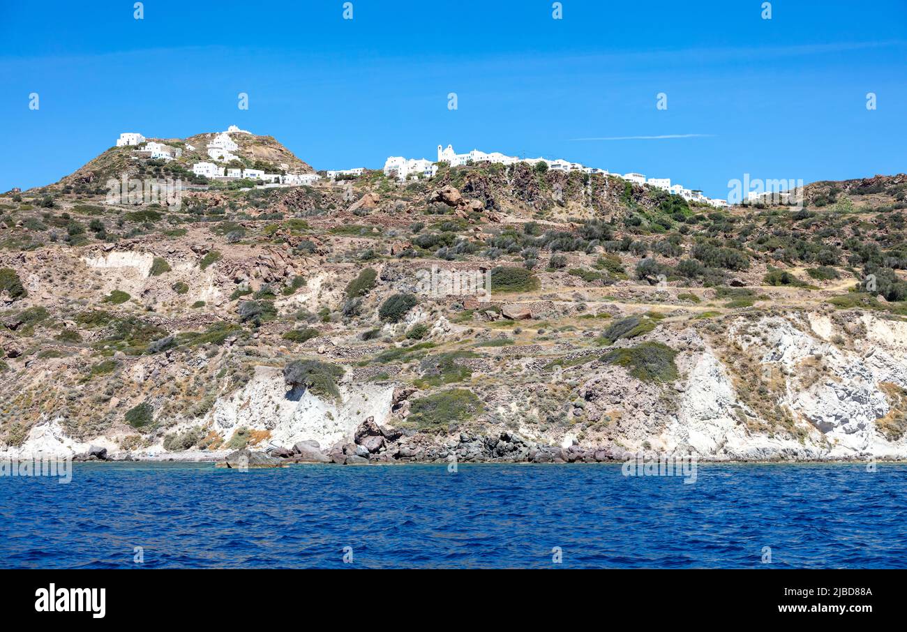 Cyclades Grèce. Île de Milos, bâtiments traditionnels en amont, Plaka Chora paysage urbain au-dessus de la falaise rocheuse, vue de la mer. Banque D'Images