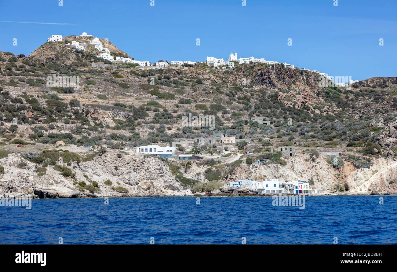 Cyclades Grèce. L'île de Milos, des bâtiments traditionnels sur la côte et des maisons de ville en amont. Maisons en bord de mer avec portes et fenêtres colorées, vue de Banque D'Images