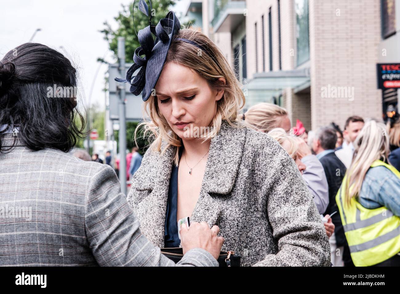 Epsom Surrey, Londres, Royaume-Uni, 04 juin 2022, femme portant un chapeau de fascinateur bleu marine achetant un billet sur une rue surpeuplée Banque D'Images