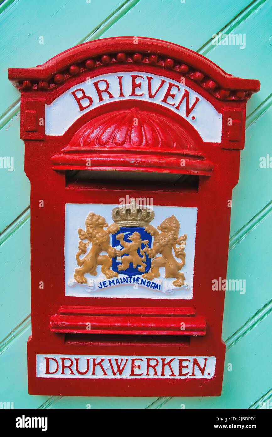 Boîte aux lettres rouge traditionnelle aux pays-Bas. Le texte dit «lettres» et «imprimés». Décoré avec les armoiries des pays-Bas. Banque D'Images