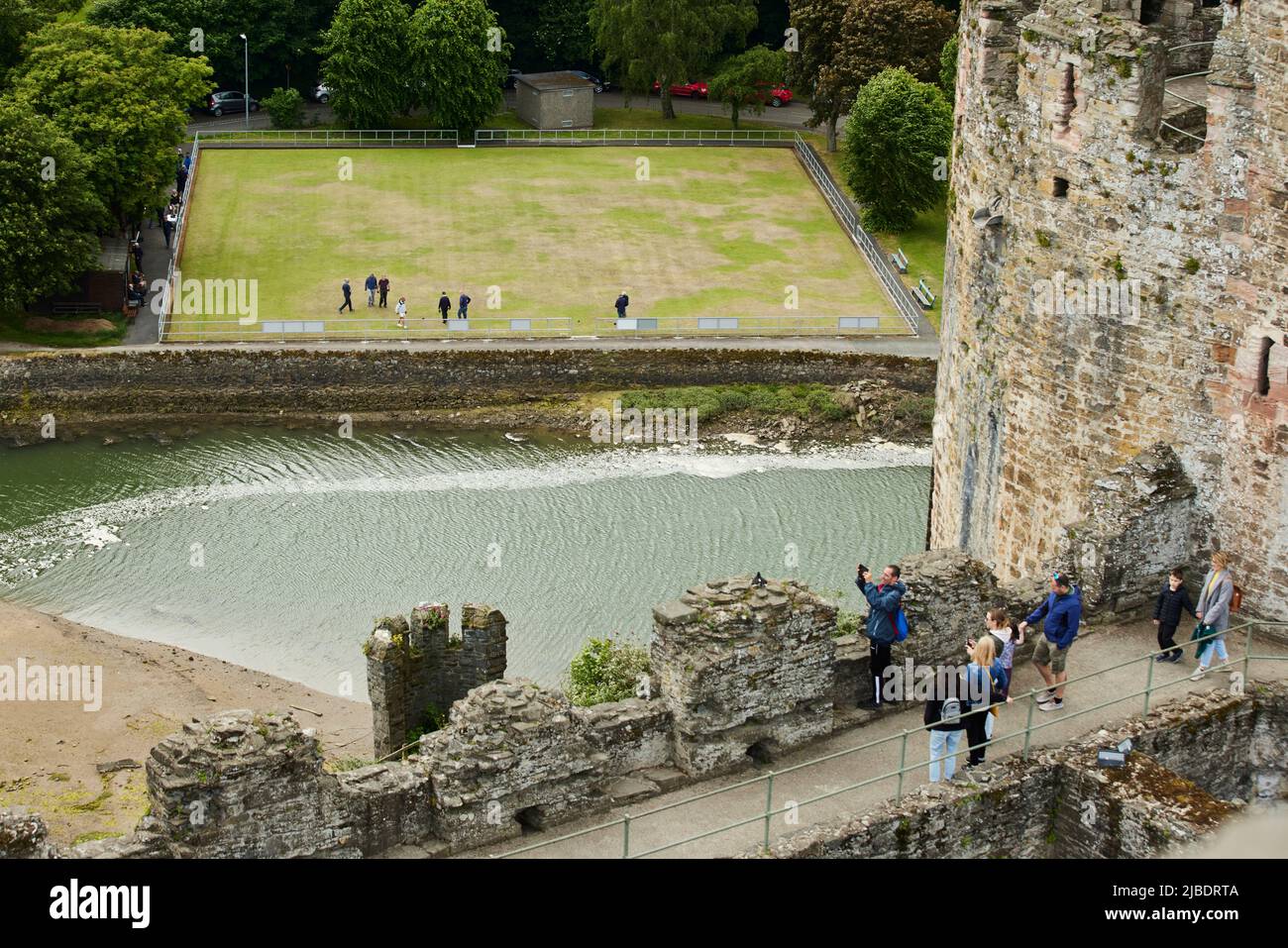 Conwy, nord du pays de Galles site médiéval structure défensive Château de Conwy avec le vert de bowling local en vue Banque D'Images