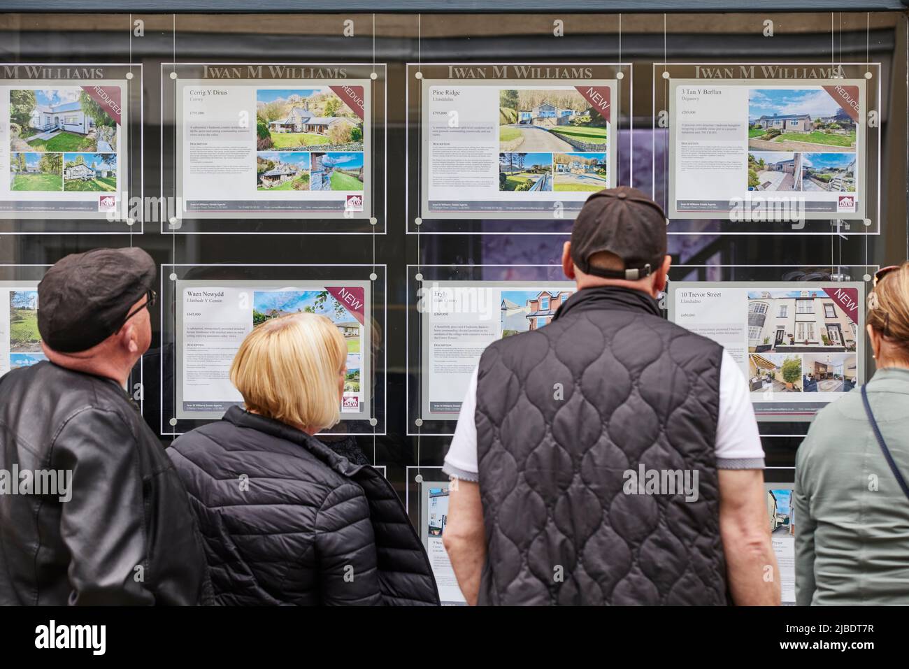 Conwy, Nord du pays de Galles touristes regardant une fenêtre d'agents immobiliers à la recherche de maisons de retraite ou de vacances Banque D'Images