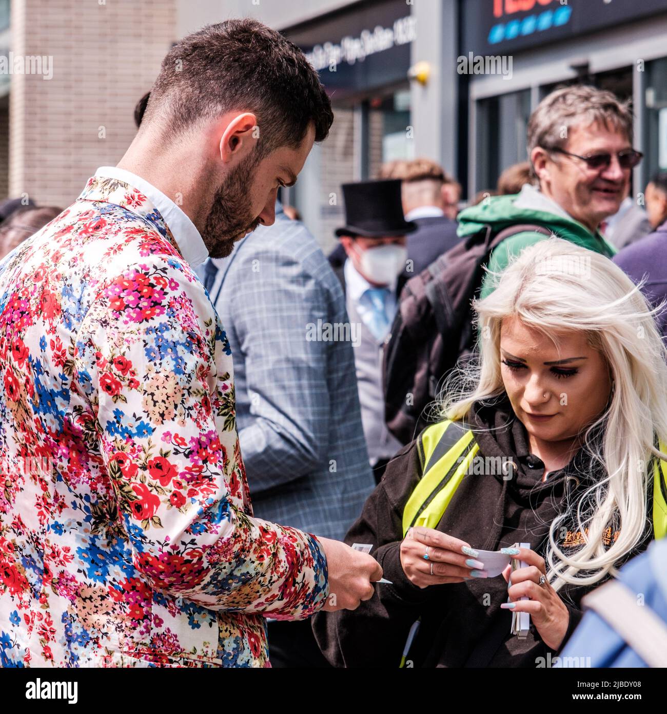 Epsom Surrey, Londres, Royaume-Uni, 04 juin 2022, un jeune homme à la mode et à la mode qui achète un billet sur une rue surpeuplée Banque D'Images
