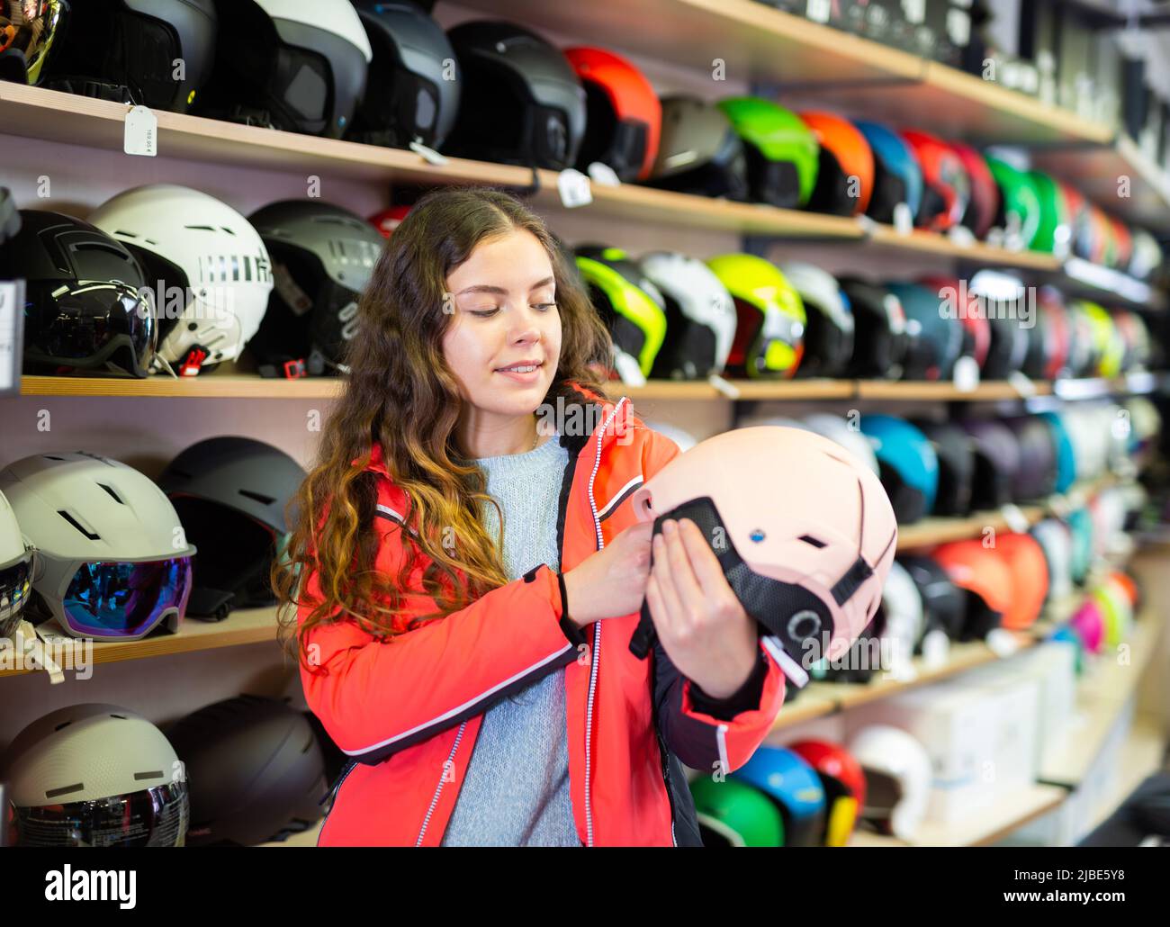 femme choisissant un casque dans un magasin d'équipement de sport Banque D'Images