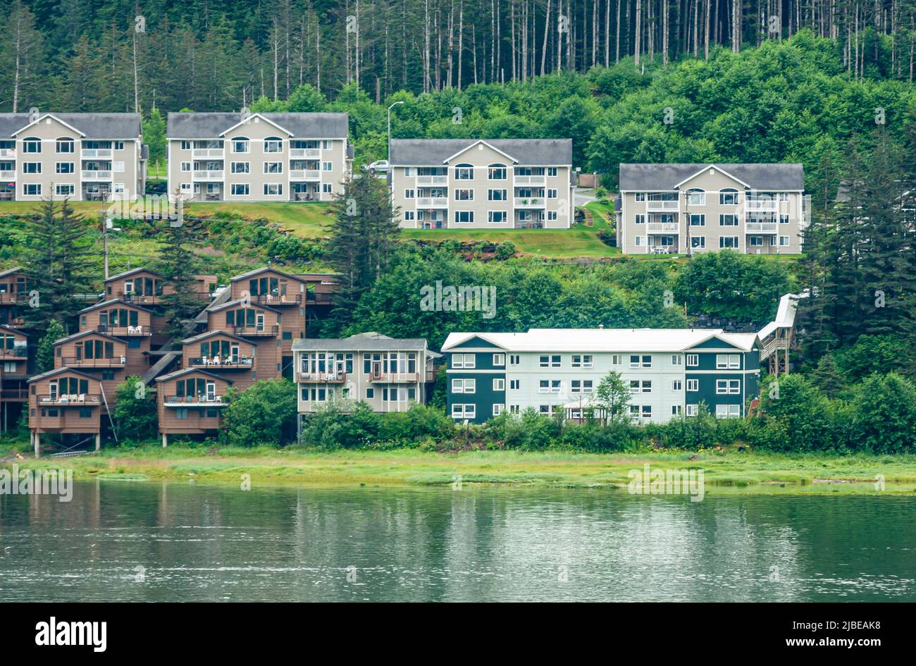 Juneau, Alaska, Etats-Unis - 19 juillet 2011: Appartements modernes sur une pente de montagne verte le long du canal de Gasineau. Toile de fond de la forêt de pins. Verdâtre Banque D'Images