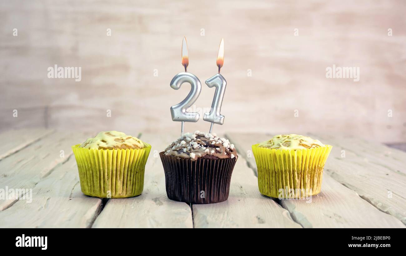 Joyeux anniversaire muffins avec des bougies avec le numéro. Espace de copie de carte avec chaussons pour Félicitations. Banque D'Images