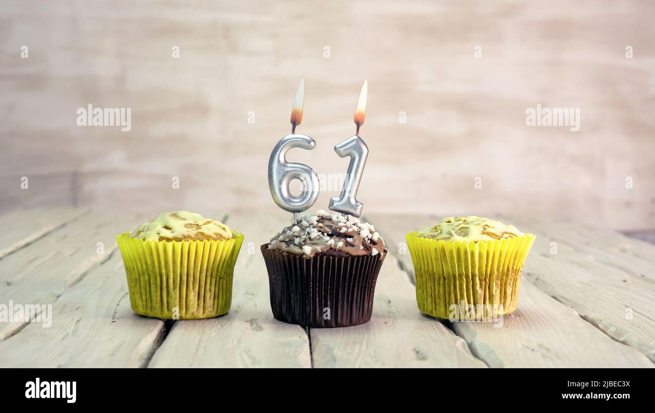 Joyeux anniversaire muffins avec des bougies avec le numéro. Espace de copie de carte avec chaussons pour Félicitations. Banque D'Images
