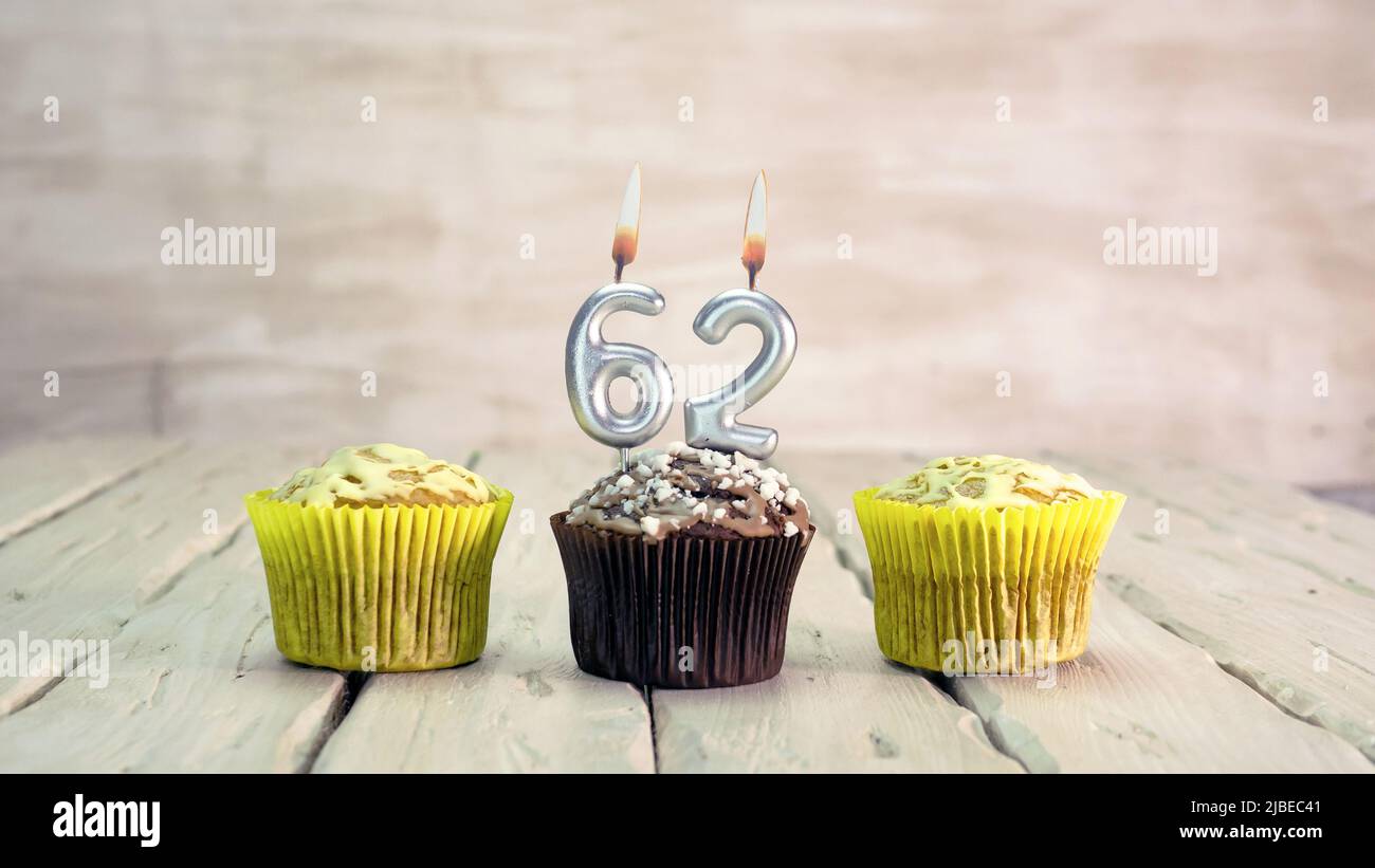 Joyeux anniversaire muffins avec des bougies avec le numéro. Espace de copie de carte avec chaussons pour Félicitations. Banque D'Images