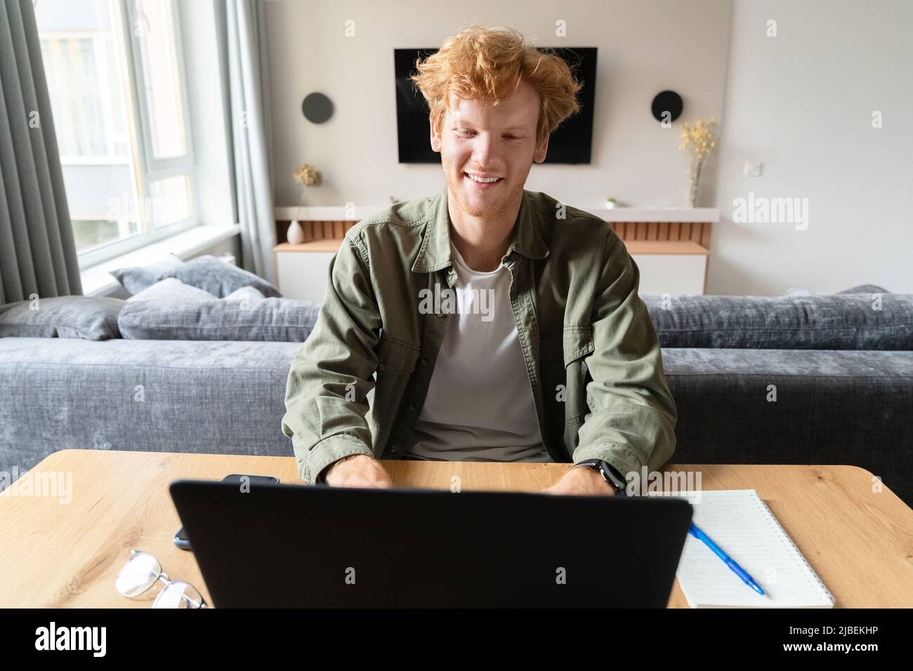 Jeune homme britannique étudiant en ligne ou ayant des conférences vidéo d'affaires sur ordinateur portable Banque D'Images