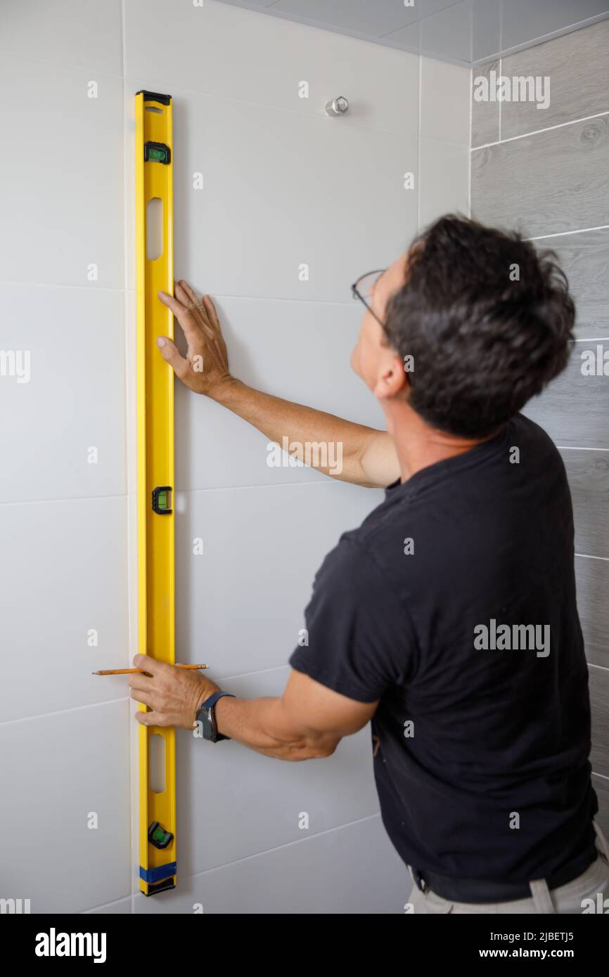 Un homme fait des réparations dans la salle de bains. Banque D'Images