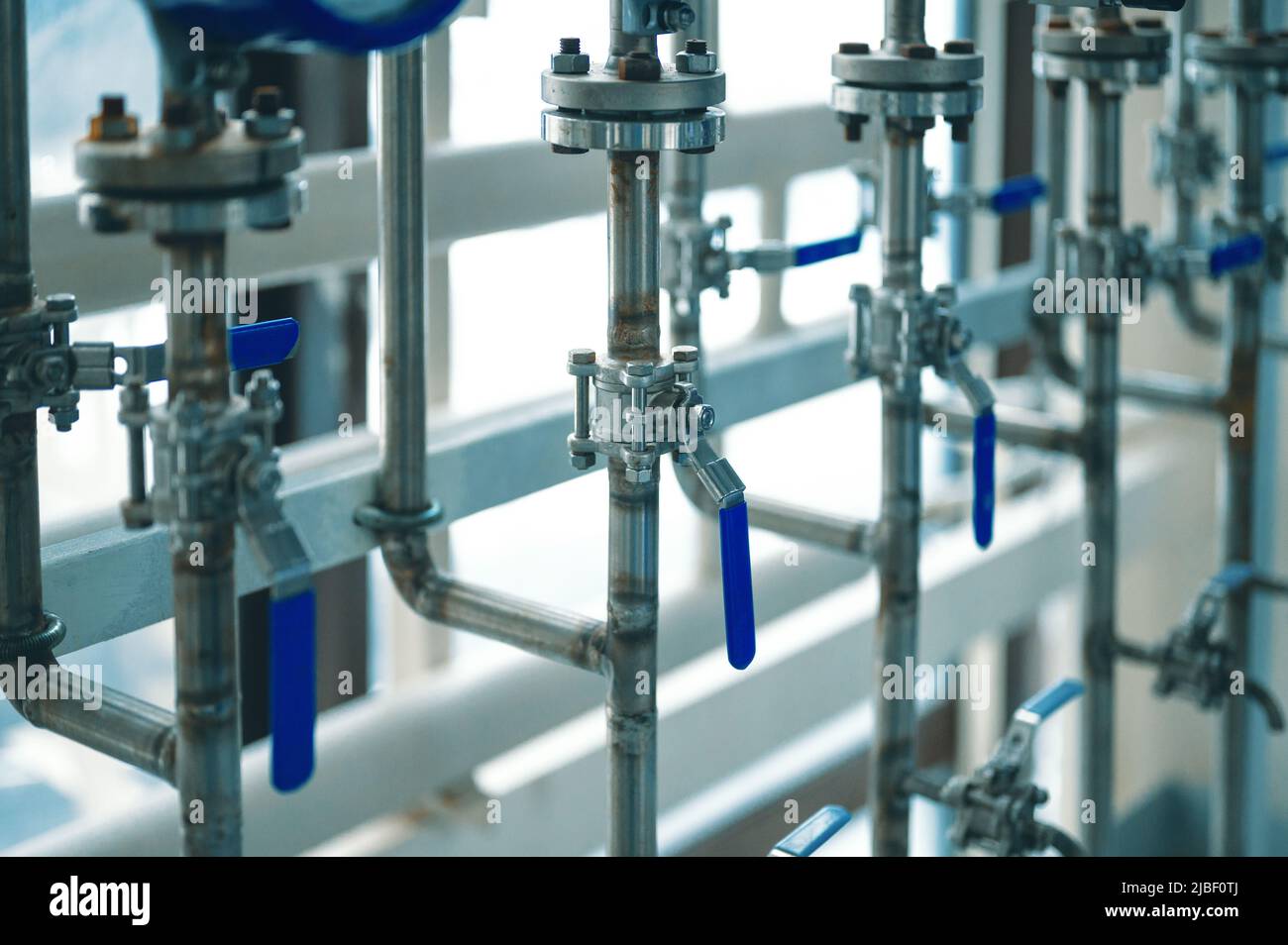 Canalisations minces avec leviers bleus ouverts et fermés à l'usine Banque D'Images