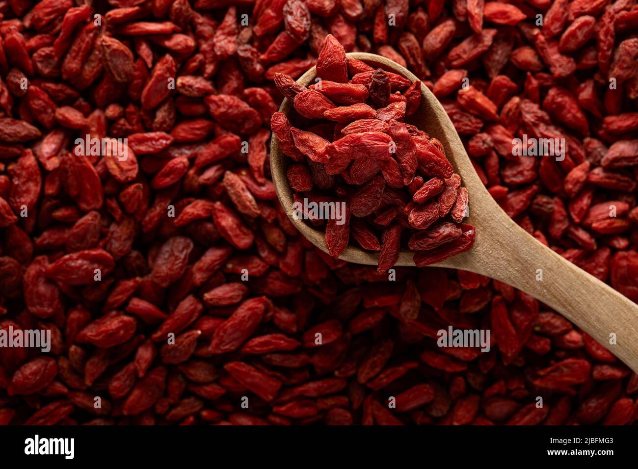 Vue de dessus d'une cuillère en bois pleine de baies de goji Banque D'Images