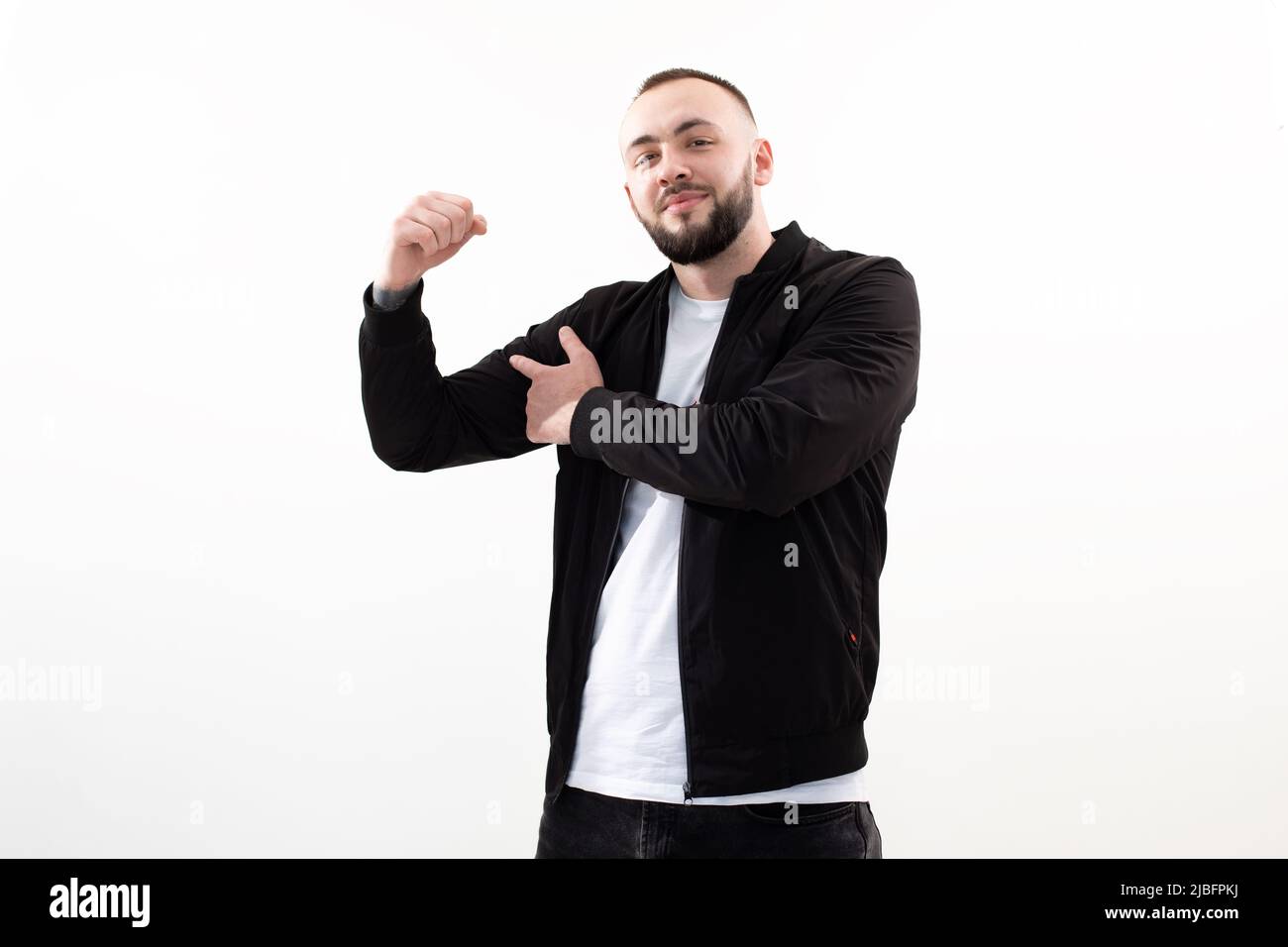 Homme souriant et confiant qui regarde l'appareil photo en studio sur fond blanc. Montrez les muscles du corps, faites du sport une énergie forte Banque D'Images