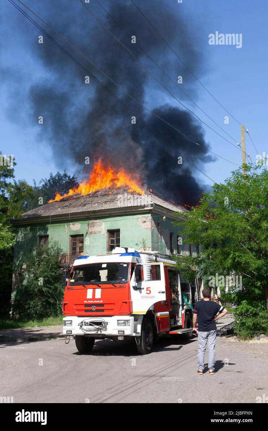 Russie, Rostov-sur-le-Don - 2 juin 2022: Des pompiers sont arrivés pour éteindre un incendie dans une maison abandonnée, une ambulance et des spectateurs sont debout n Banque D'Images