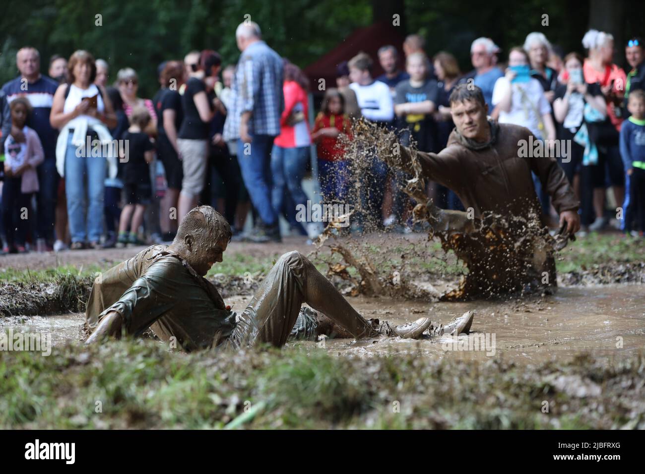 Hergisdorf, Allemagne. 06th juin 2022. Les hommes s'assoient dans un trou de boue au Dirty Pig Festival de 2022 à Hergisdorf sur le site du festival sur le Wildbahn. À la fête de la forêt, l'hiver est symboliquement chassé par le festival Dirty Pig. Pour cela, les hommes sautent dans un trou de boue. Credit: Matthias Bein/dpa/Alay Live News Banque D'Images