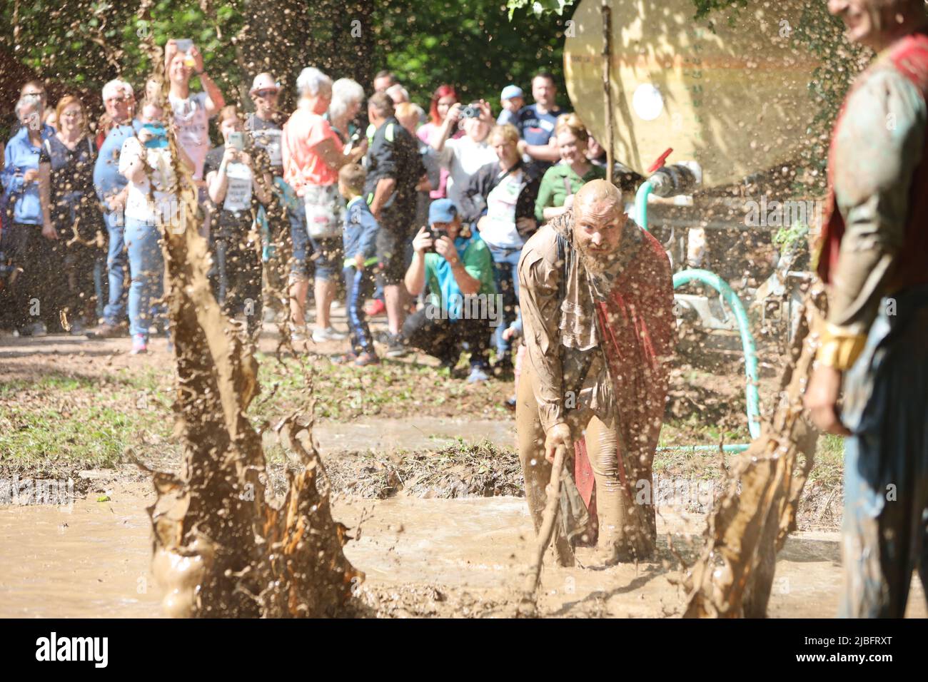 Hergisdorf, Allemagne. 06th juin 2022. Les hommes s'assoient dans un trou de boue au Dirty Pig Festival de 2022 à Hergisdorf sur le site du festival sur le Wildbahn. À la fête de la forêt, l'hiver est symboliquement chassé par le festival Dirty Pig. Pour cela, les hommes sautent dans un trou de boue. Credit: Matthias Bein/dpa/Alay Live News Banque D'Images