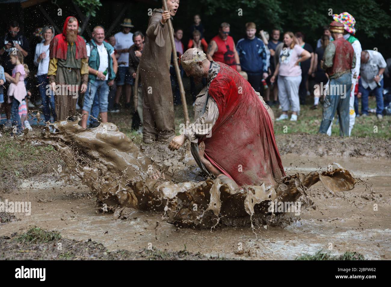 Hergisdorf, Allemagne. 06th juin 2022. Les hommes s'assoient dans un trou de boue au Dirty Pig Festival de 2022 à Hergisdorf sur le site du festival sur le Wildbahn. À la fête de la forêt, l'hiver est symboliquement chassé par le festival Dirty Pig. Pour cela, les hommes sautent dans un trou de boue. Credit: Matthias Bein/dpa/Alay Live News Banque D'Images