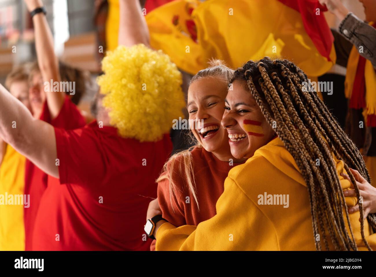 Les fans de football heureux qui ont suppdu l'équipe nationale espagnole dans un match de football en direct au stade, célébrant. Banque D'Images