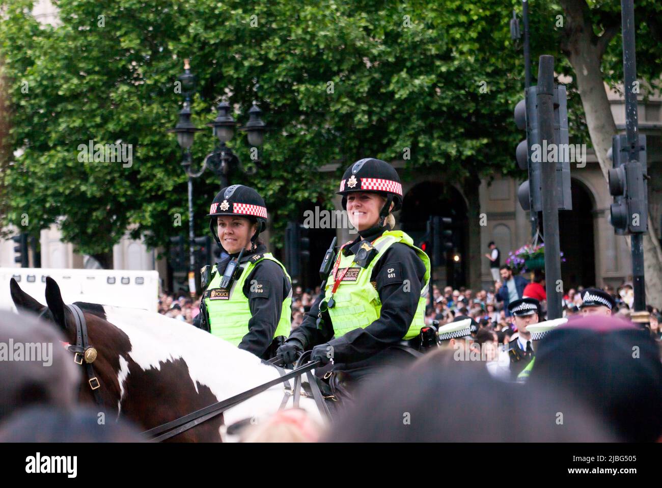 Gros plan de deux officiers de police féminins montés souriant devant la foule, à la fin du survol pour célébrer le Trooping de la couleur : la parade d'anniversaire de la Reine, dans le cadre de ses célébrations du Jubilé de platine 2022 Banque D'Images