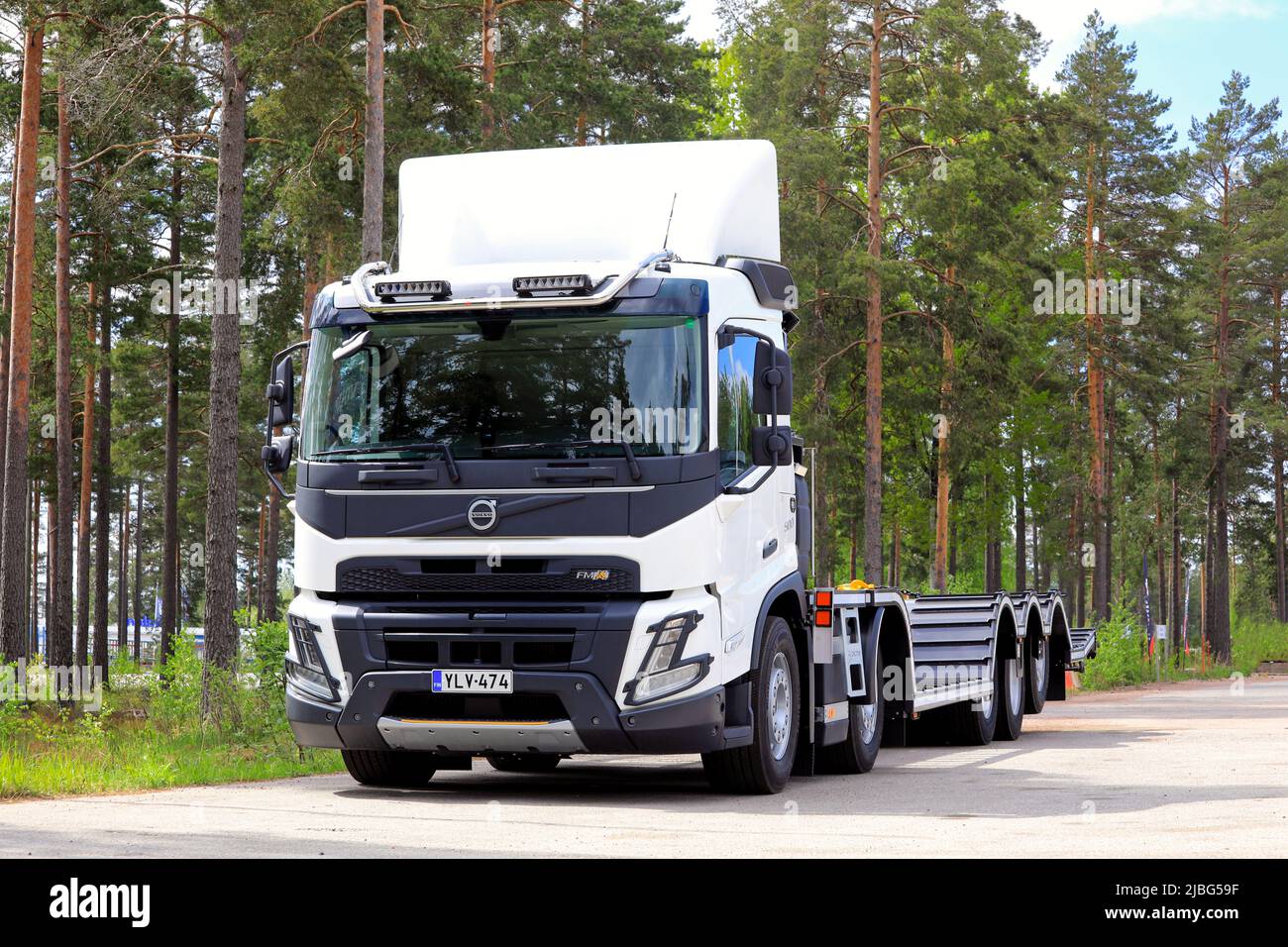 Nouveau camion FMX Volvo blanc devant une remorque de transport de véhicules forestiers garée sur une cour asphaltée. Raasepori, Finlande. 26 mai 2022. Banque D'Images Nouveau camion FMX Volvo blanc devant une remorque de transport de véhicules forestiers garée sur une cour asphaltée. Raasepori, Finlande. 26 mai 2022. Banque D'Images